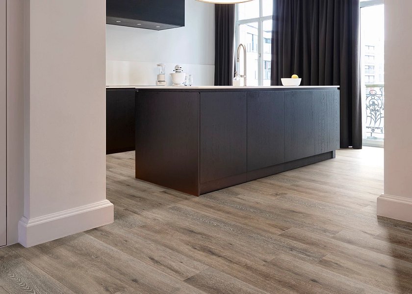COREtec Flexile Acorn 50 FLX 854 Vinylboden, braune Holzoptik, in einem Raum verlegt, zeigt die langlebige Klebevinyl-Textur.